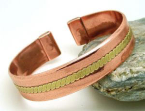 A brass twist pressed into a plain copper band. Each end is fitted with rare earth magnets